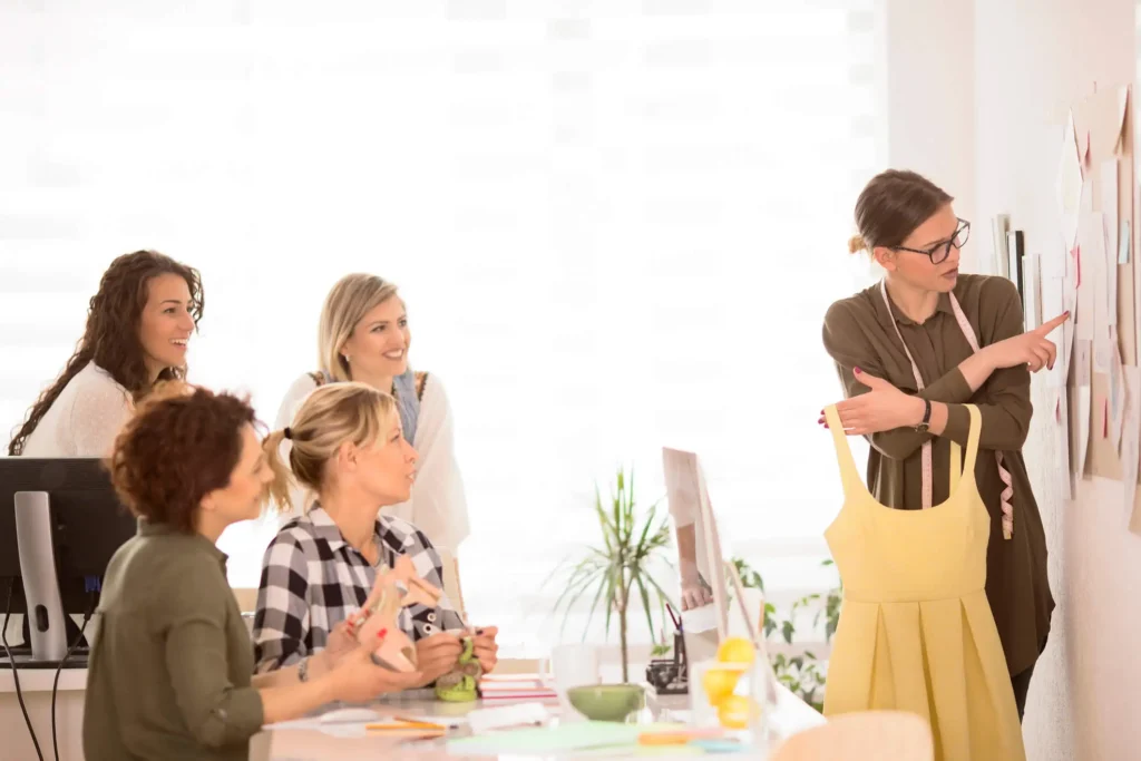 A group of fashion professionals receiving training as part of their membership in a production guild.