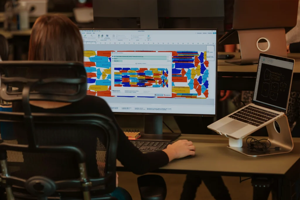 Modelista faz o encaixe de moldes num software de CAD têxtil.