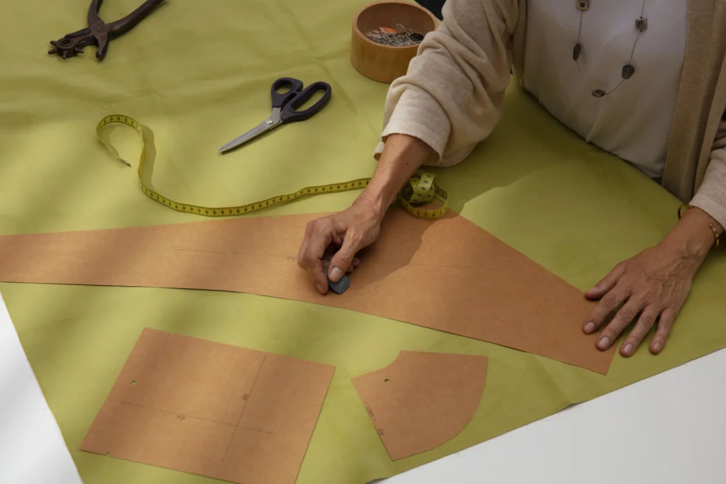 Una mujer utilizando un patrón de costura, aplicando las instrucciones para aprender cómo interpretar un patrón de costura correctamente.