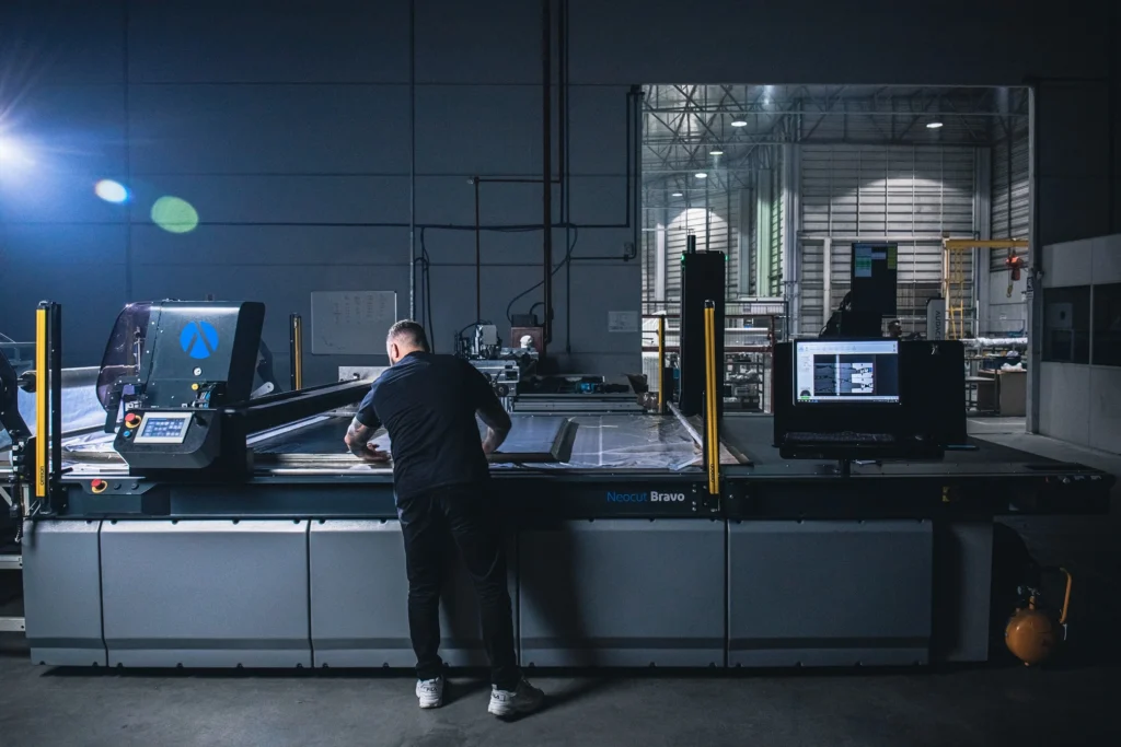 Supervisor adjusting an Audaces Neocut Bravo cutting machine. 