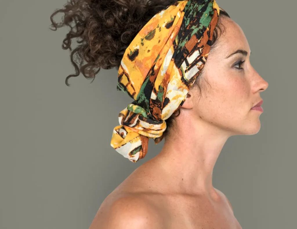 Mulher usando um lenço colorido na cabeça. O lenço é uma microtendência para 2026.