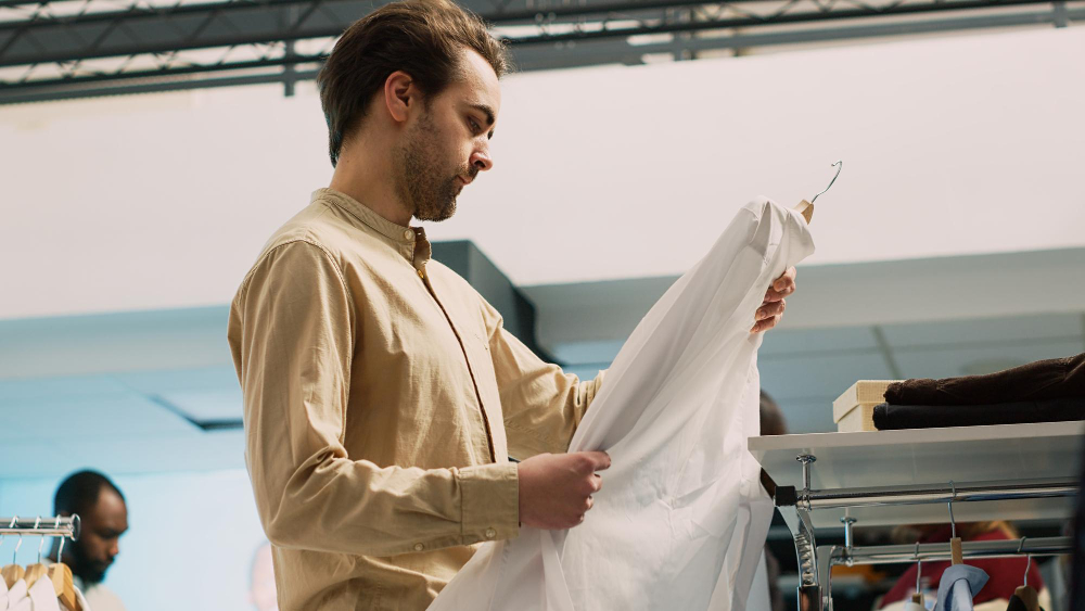 A man holding a shirt produced via cleaner production in the fashion industry.