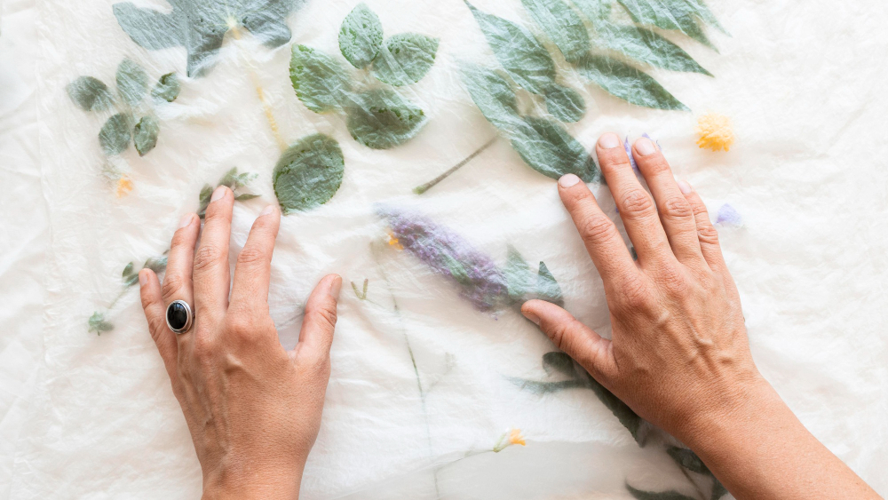 A person doing natural dyeing using the botanical print technique.