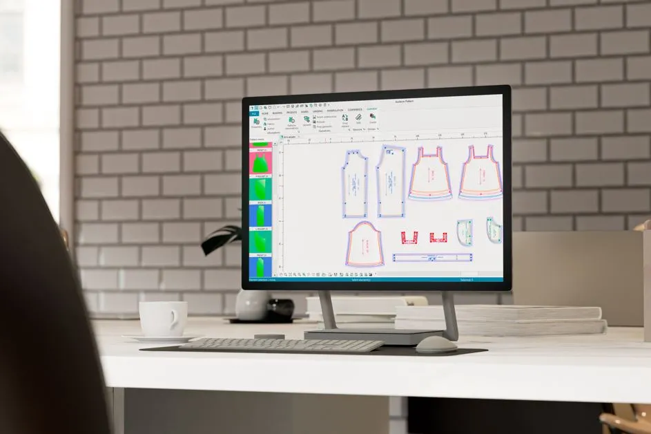 A fashion professional using CAD software for flat pattern making.
