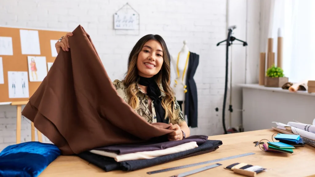 Diseñadora analizando las propiedades de la tela sobre una mesa de trabajo.