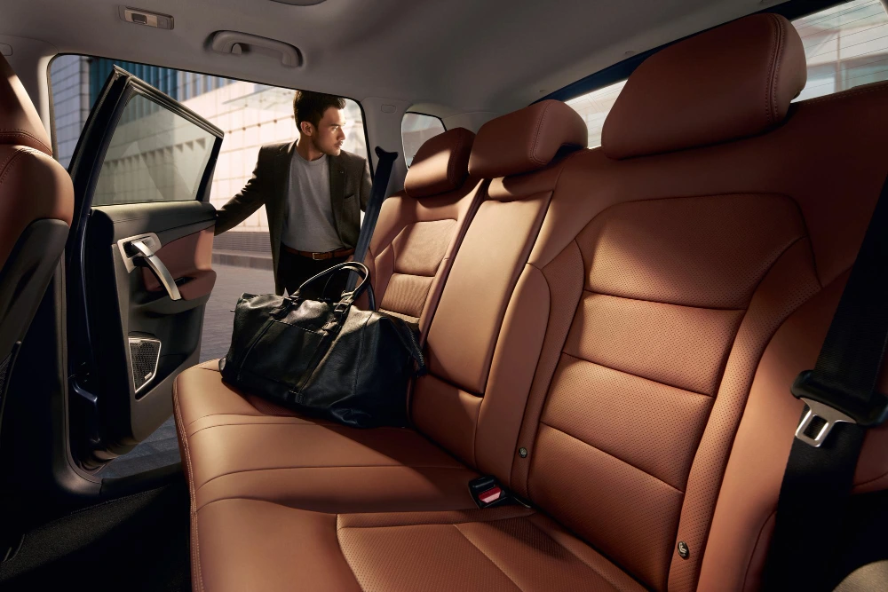 Emerging auto trends: A person standing at the open door of a car with modern upholstery.