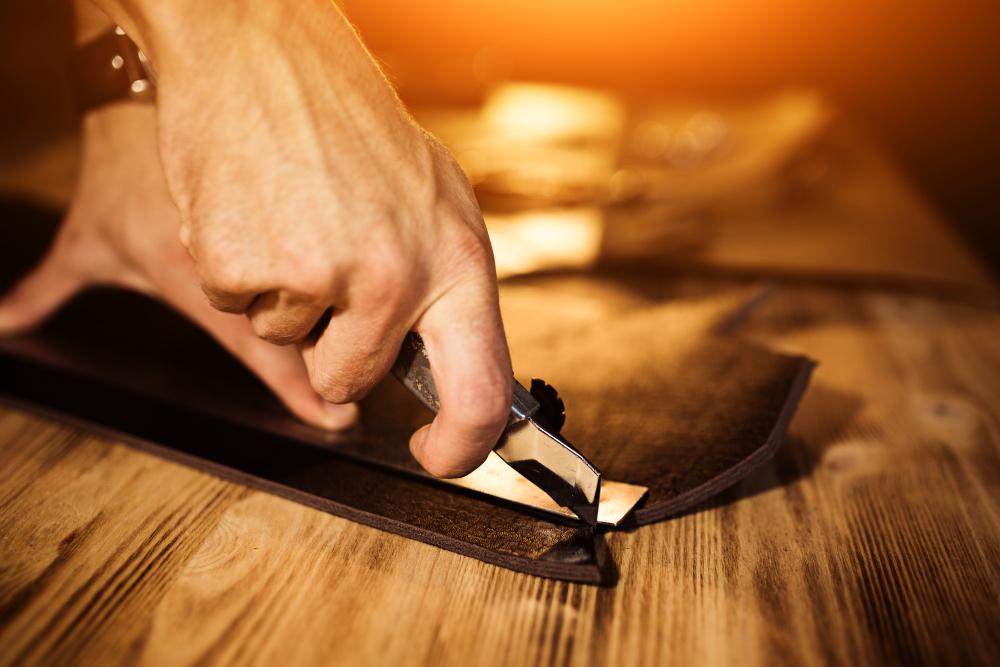 Leather cutting tools: a worker using a manual method to cut the material.