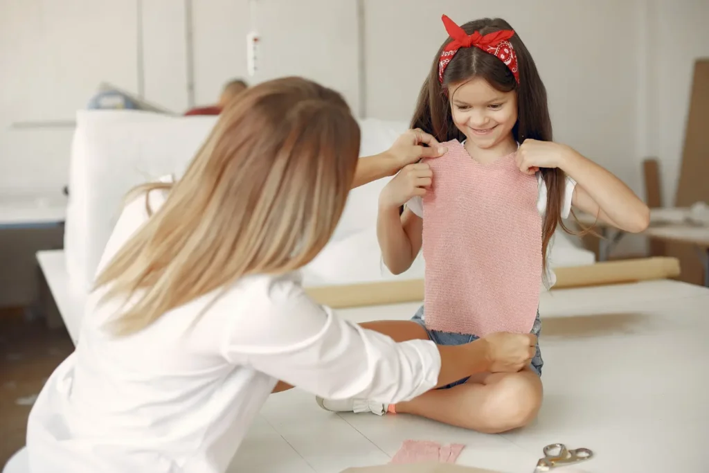 Modelista profissional testando um molde de modelagem infantil diretamente em uma criança
