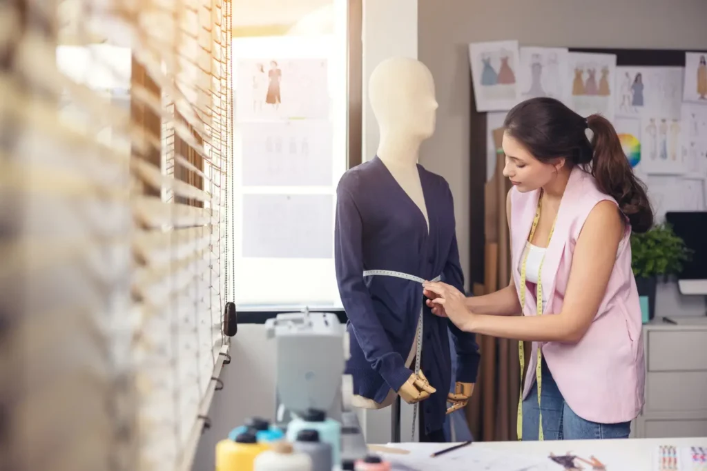 Modelista testando roupa em um manequim, fazendo a análise ergonômica da modelagem da roupa.