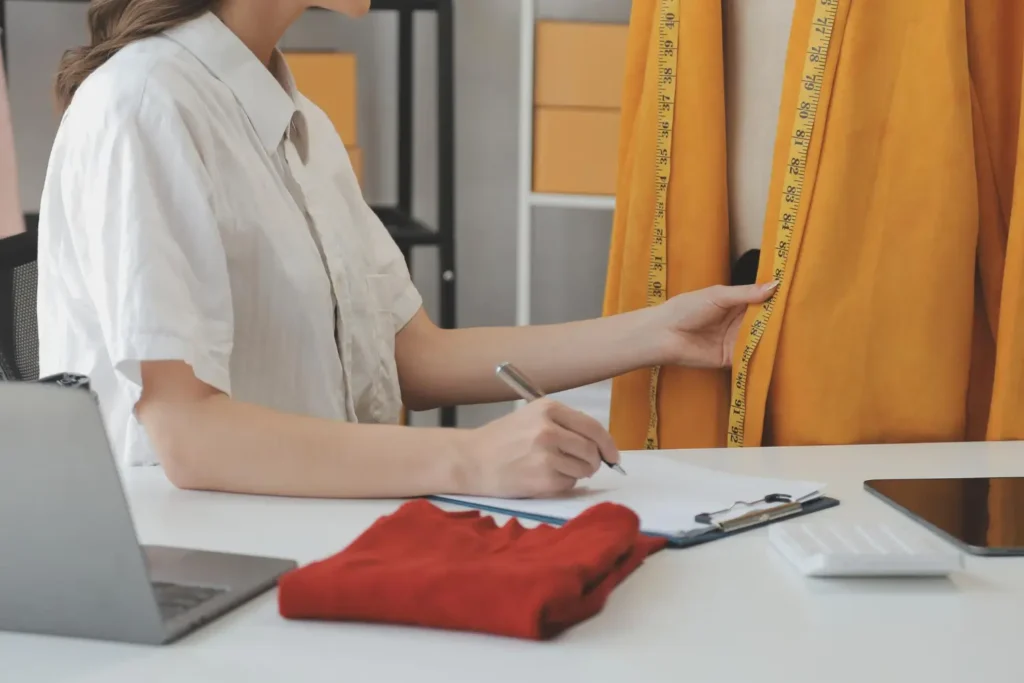Modelista conferindo o tecido para criar peças plus size
