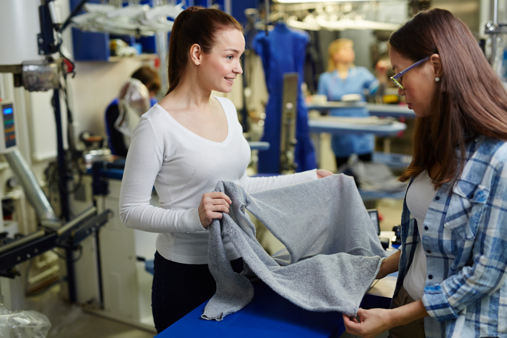 Plotter machine: two fashion professionals evaluating a garment.