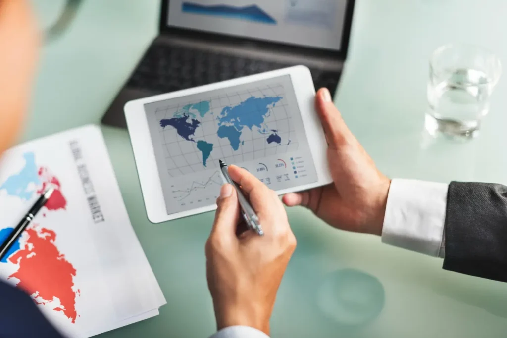 Executivos contemplando um mapa em um tablet, representando a expansão internacional do programa Texbrasil
