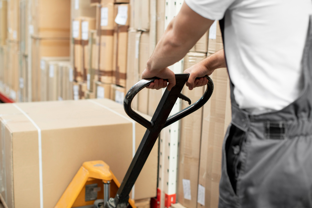 Material handling: a man in the industry using simple equipment to transport boxes.