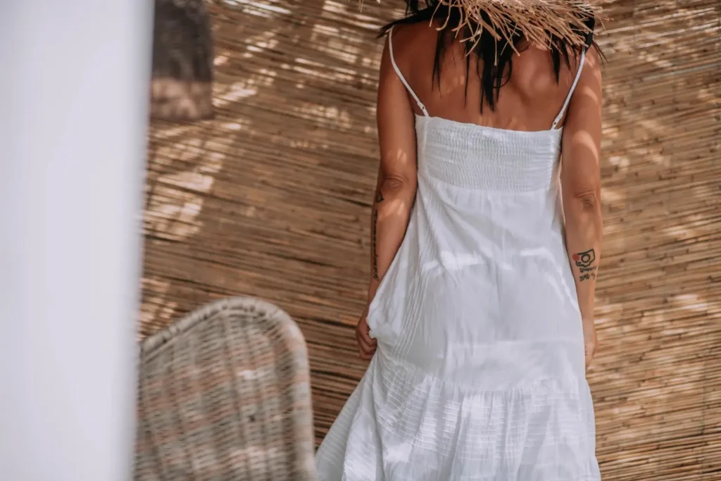 Mulher de costas vestindo um vestido midi, uma das peças de roupas mais versáteis que existe.