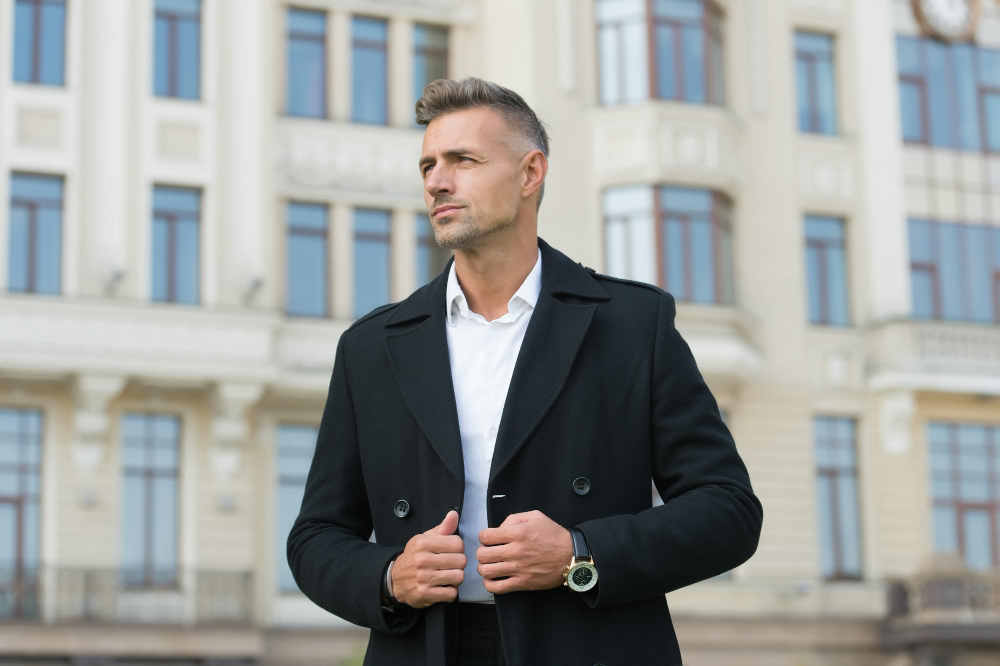 Types of shirts:A middle-aged man wearing a black coat in an urban setting.