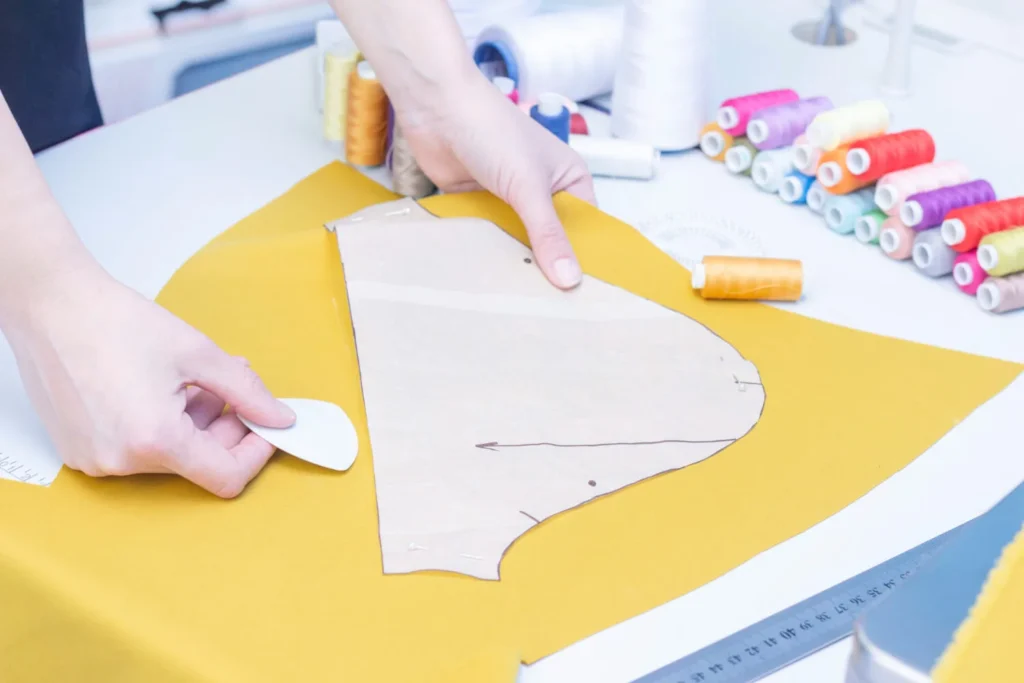 Profesional creando líneas y marcas a partir de patrones de costura.