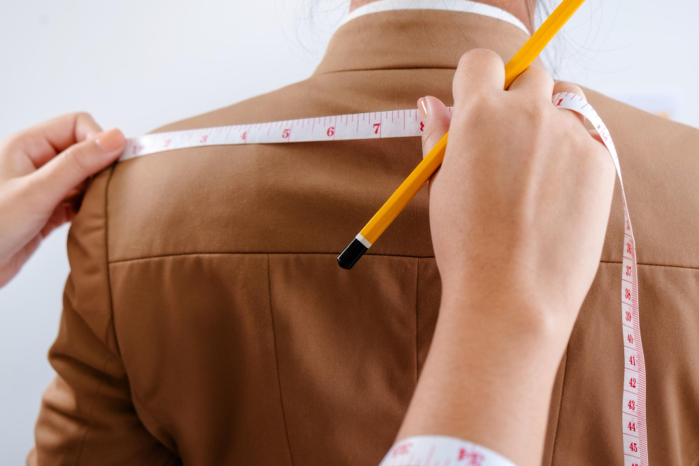 Size scale: a pattern maker measuring a client with a tape measure.