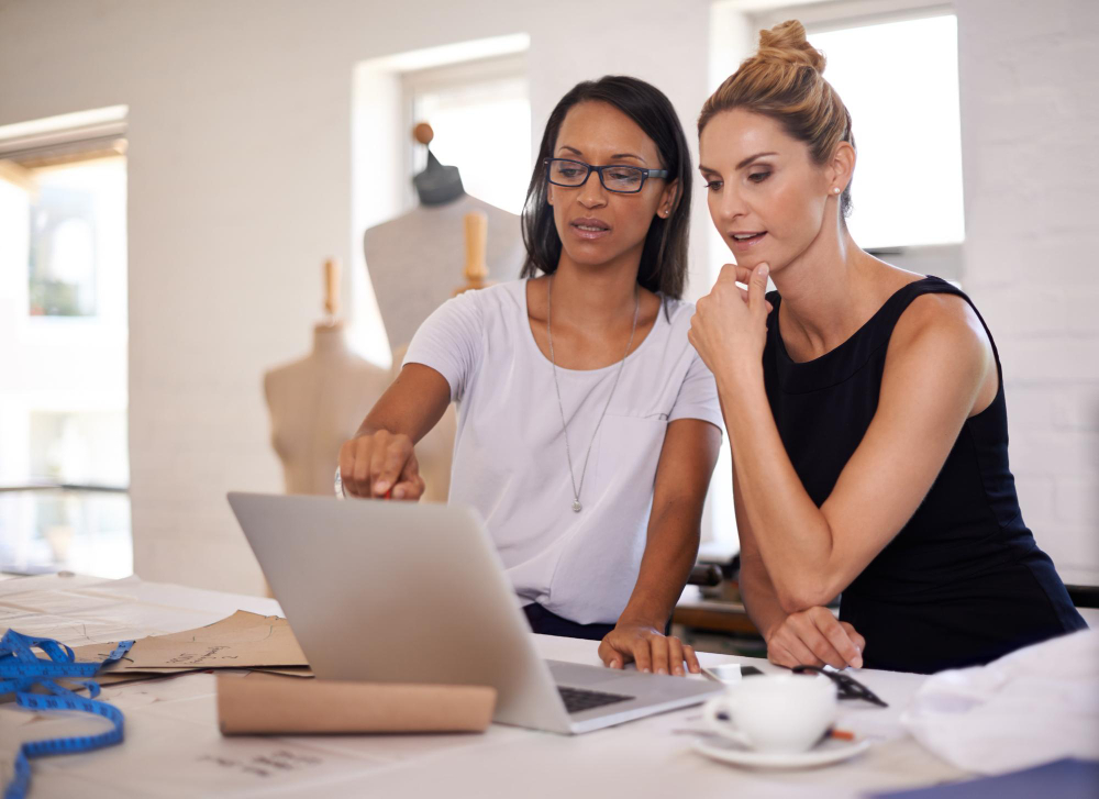 System integration: two fashion professionals working together on a computer.