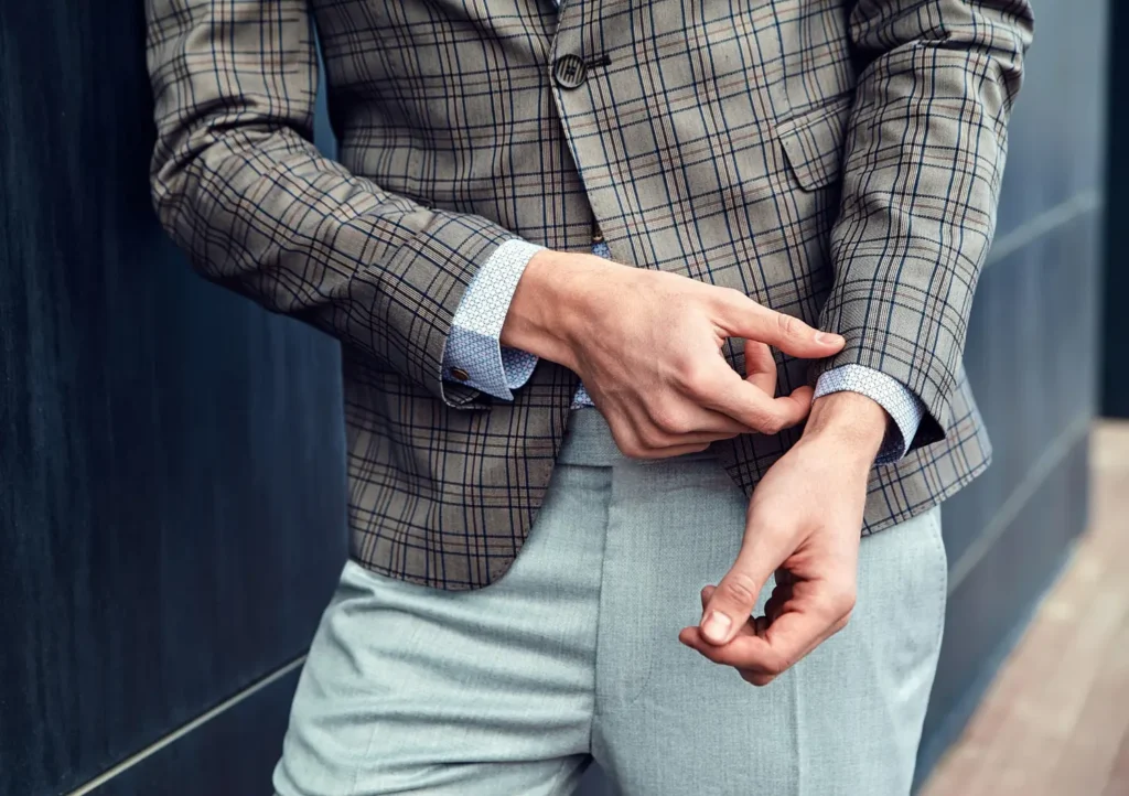 Casaco xadrez e camisa branca com punho simples, um dos tipos de punho mais comuns na modelagem.