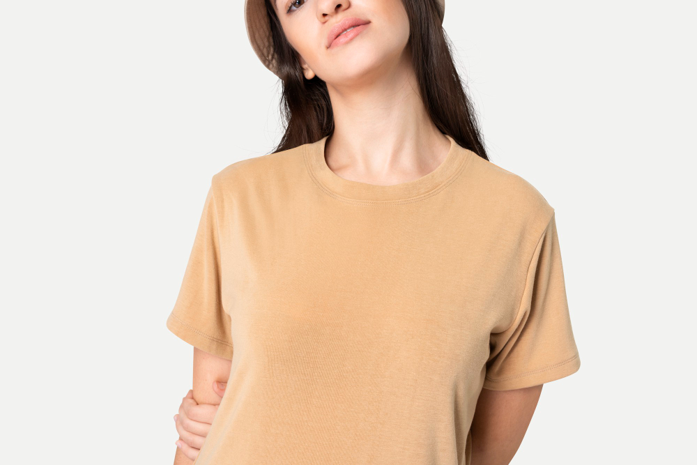 Versatile clothing: a woman wearing a beige t-shirt on a white background.