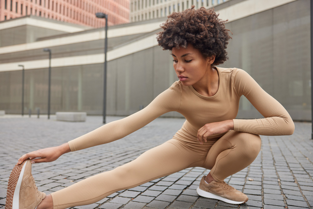 Activewear: a woman stretching wearing beige sportswear.