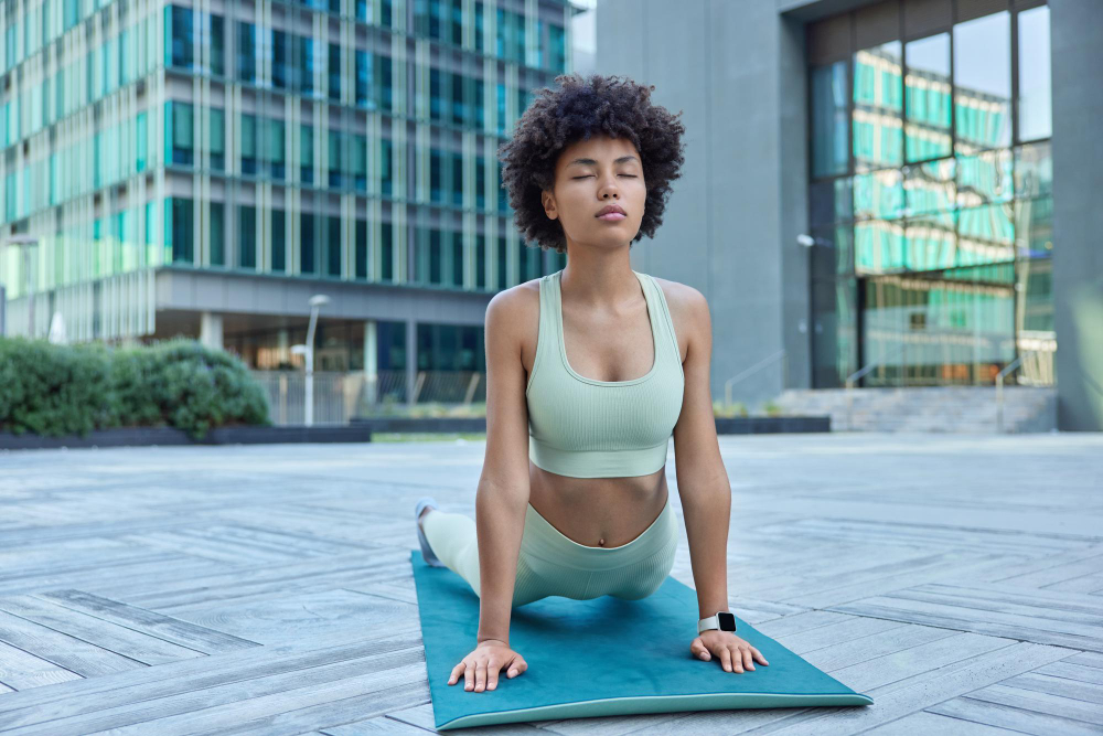 Activewear: a woman practicing yoga wearing light green clothing.