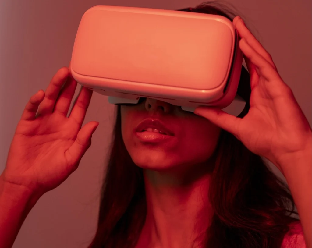 Giovane ragazza illuminata di rosso che usa la realtà virtuale