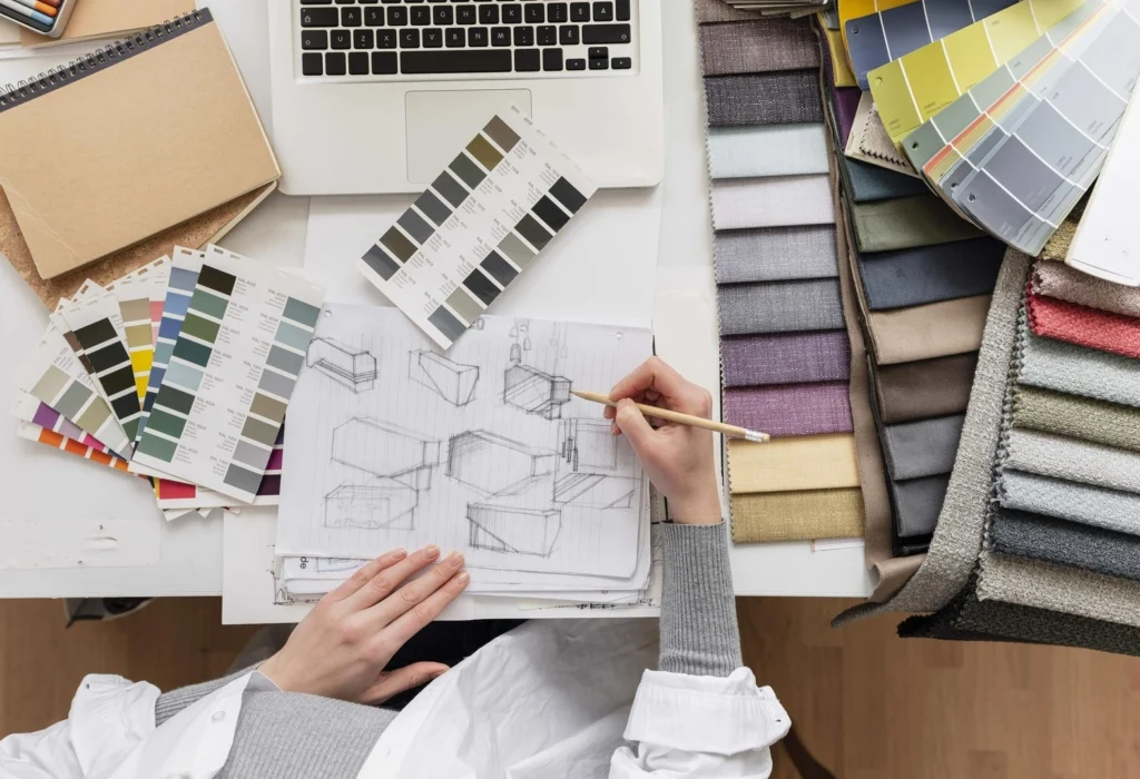 Mani che disegnano mobili per il CAD arredamento, con tessuti e colori