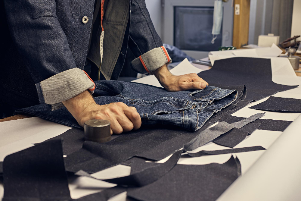 Machines that cut fabric: a fashion professional working with denim.