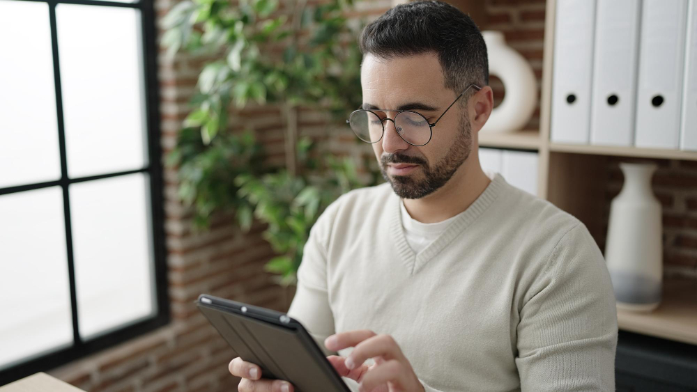 Process of textile production: a man using a tablet to track production remotely.