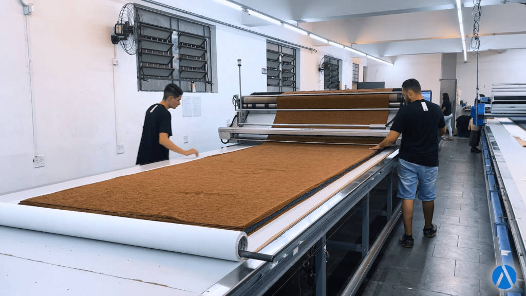 Gesti&oacute;n de producci&oacute;n: profesionales manejando una tela en una extendedora autom&aacute;tica de Audaces