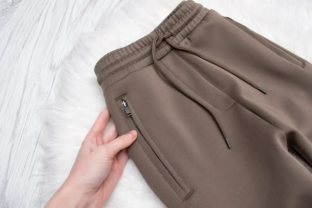 Cós elástico em uma calça de moletom marrom-acinzentada, um dos tipos de cós mais usados no mercado