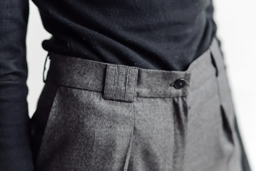 Types of waistbands: close-up of a gray high-waisted tailored pair of pants.