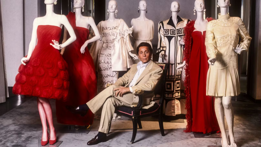 Valentino Garavani: the iconic Italian designer seated in front of his creations.