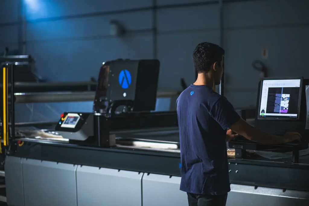 Operador usando o computador da m&aacute;quina de corte inteligente Audaces Neocut Bravo