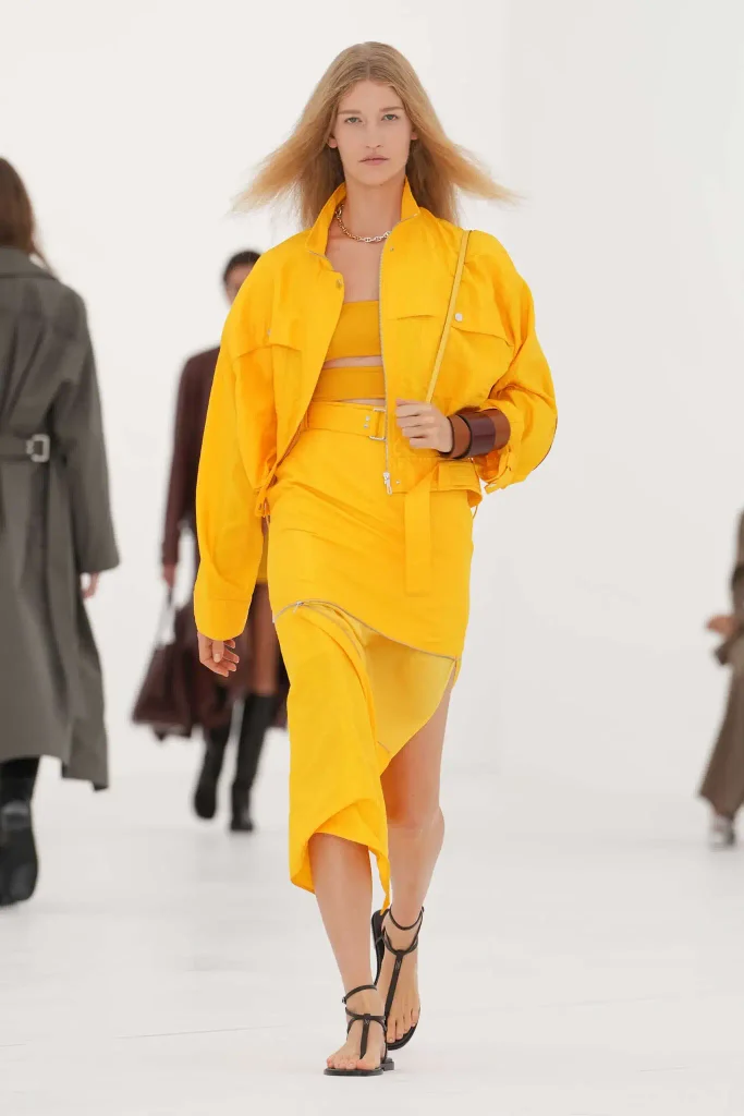 tendencias primavera verano 2027: modelo desfilando con look amarillo mostaza
