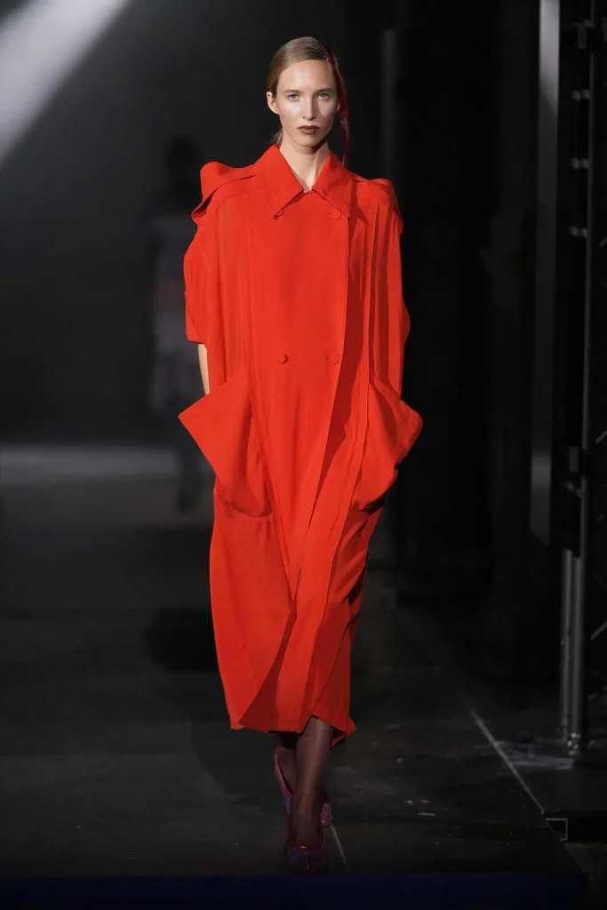 tendencias primavera verano 2027: modelo desfilando con abrigo naranja