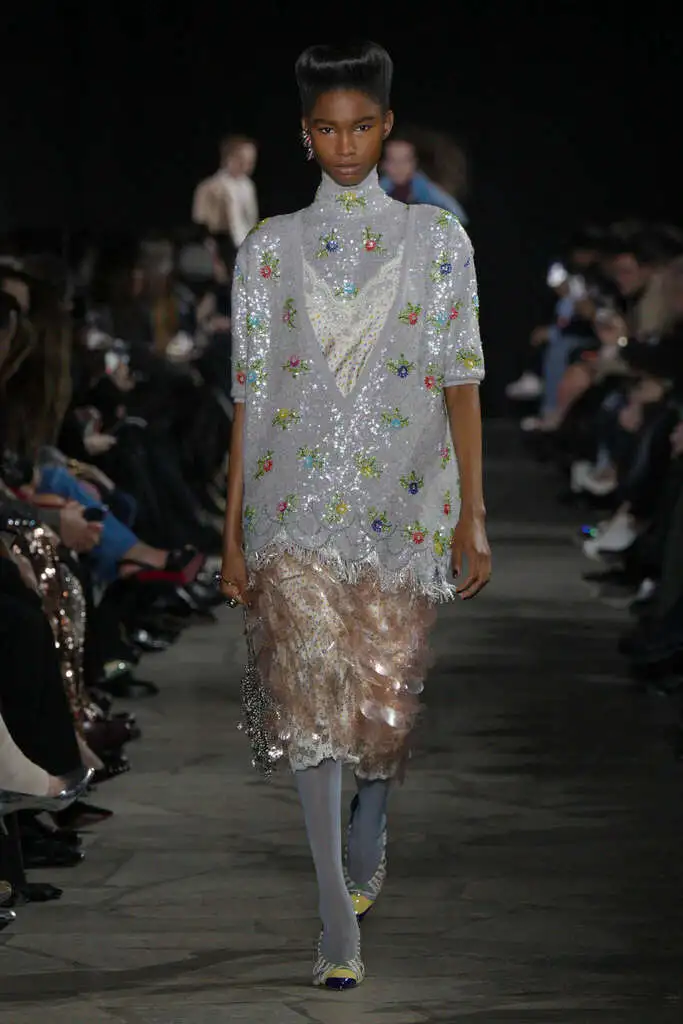 moda otoño invierno: modelo desfilando con un look con lentejuela y flores.