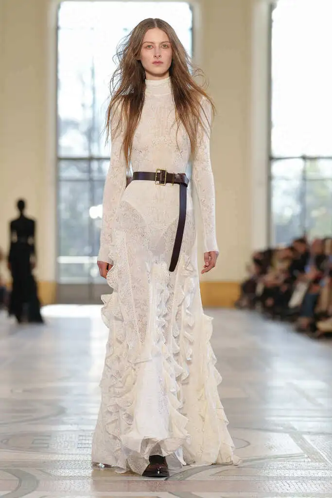 moda otoño invierno: modelo desfilando con un look blanco con transparencias.