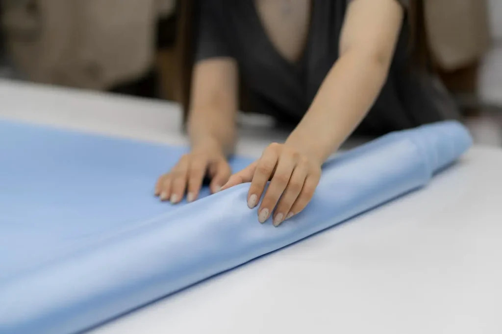 M&aacute;quinas industriales: mujer haciendo el extendido de una tela en una mesa