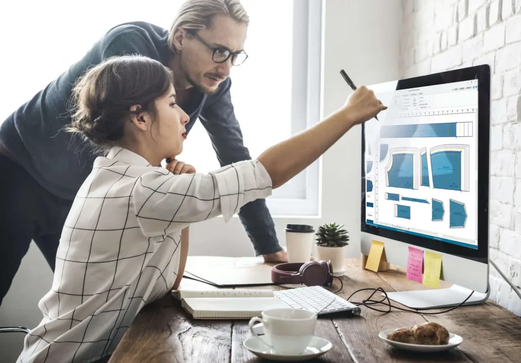 patrones de blusas: dos personas creando patrones de blusas desde una computadora