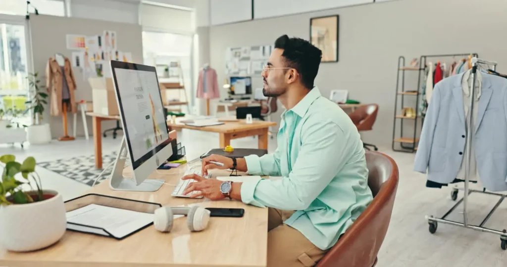 cad en la industria: hombre mirando la pantalla de una computadora en un taller de ropas