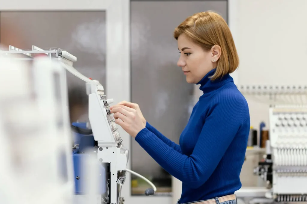 ingenier&iacute;a textil: mujer operando uma m&aacute;quina textil.