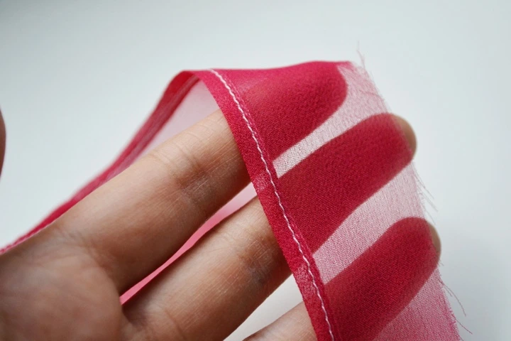 Types of hems: an example of a rolled hem on a lightweight red fabric.