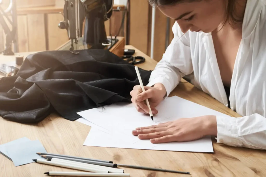 derechos de autor: mujer firmando un documento en un taller de ropas