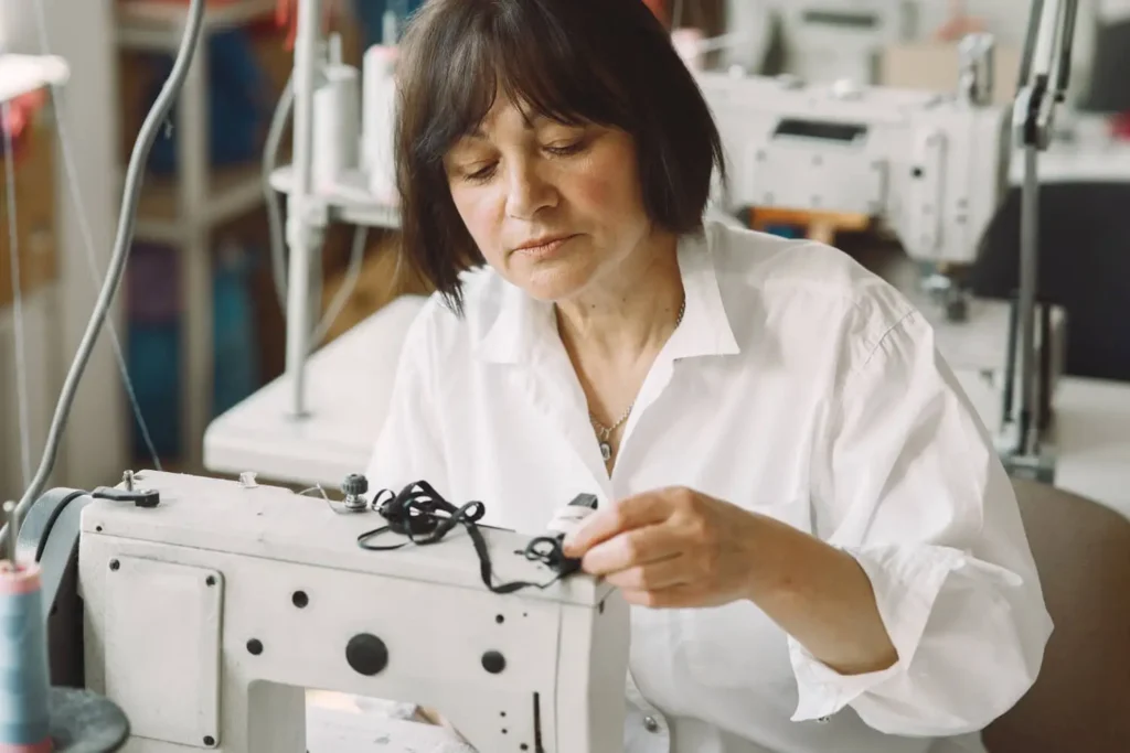 industria textil en colombia: mujer usando una m&aacute;quina de coser