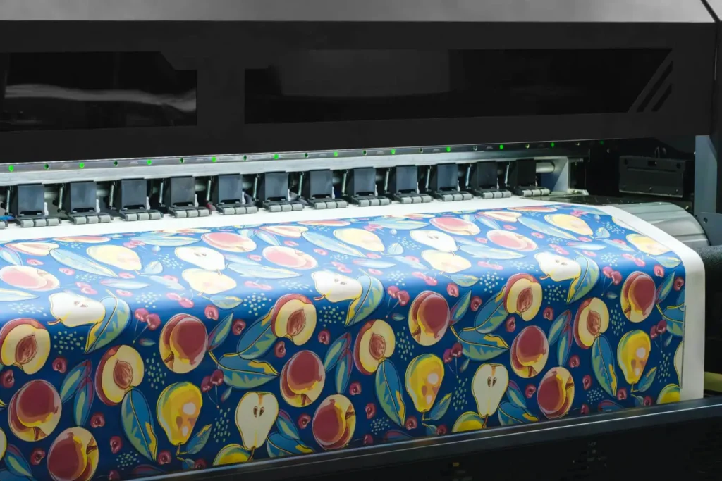 impresi&oacute;n textil: tela con estampado de frutas siendo impresa por una m&aacute;quina