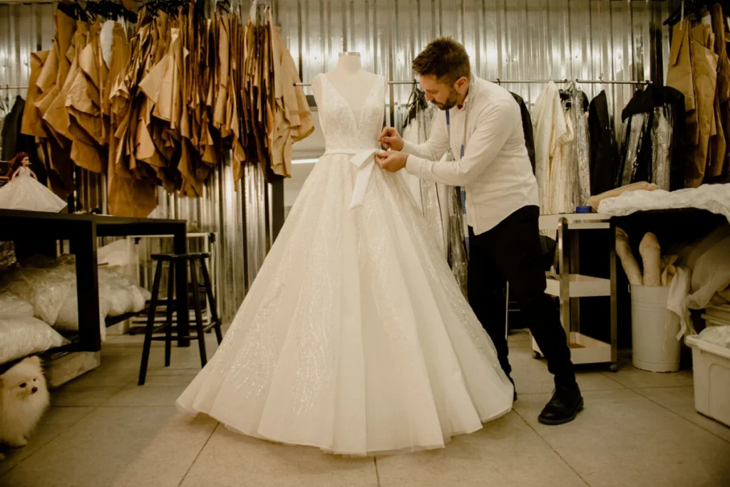 Lucas Anderi ajustando um vestido de noiva. Créditos: Disney/Divulgação