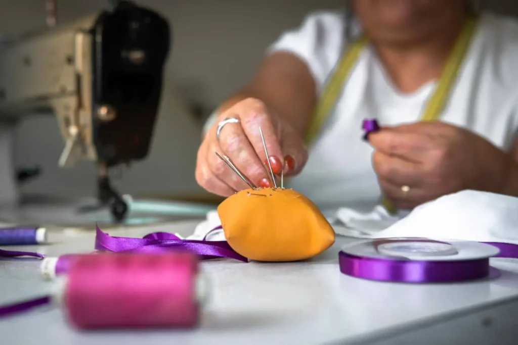 avíos textiles: persona en un taller de costura con agujas de coser