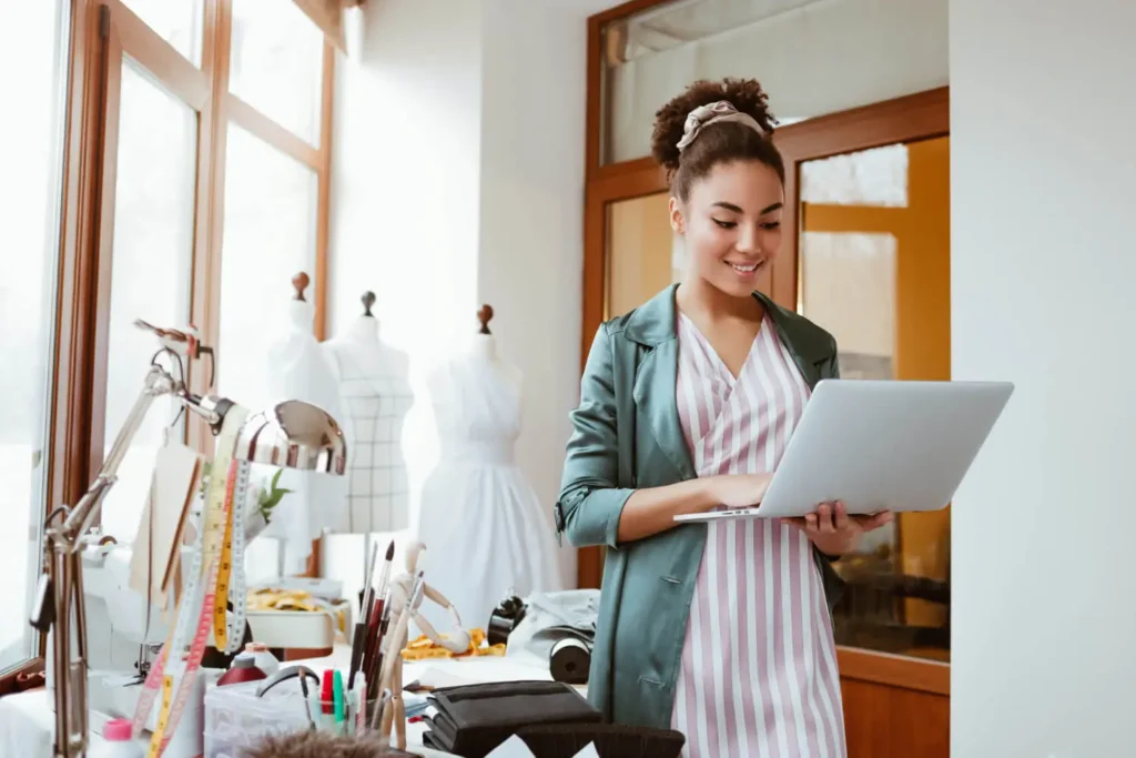 dise&ntilde;o asistido por computadora: mujer con una computadora en un taller de costura